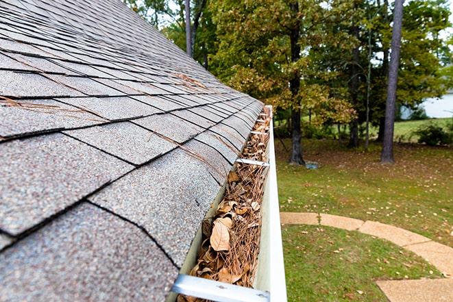 a person using a power washer to clean out gutters